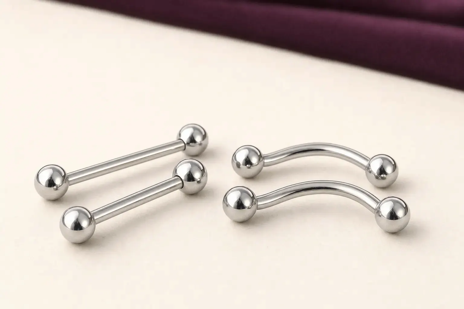 Zwei gerade Barbells neben zwei gebogenen Bananen, jeweils mit zwei Kugeln